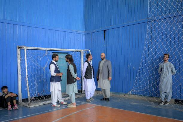 Taliban members chat as youths show their skills during an event organised for the visit of Taliban's director of physical education and sports...