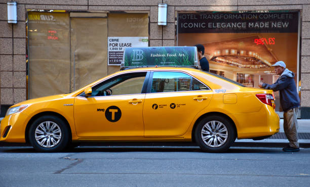 taxi driver stands near his taxi cab on a new york city street picture