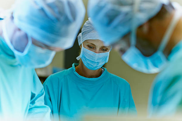 team of surgeons in operation room - cirurgia - fotografias e filmes do acervo