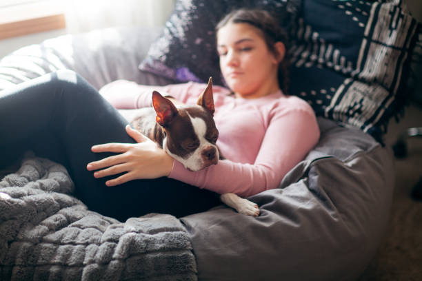 teenage girl cuddling with her Boston Terrier