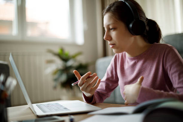 teenage girl with headphones having online school class at home - learning stock pictures, royalty-free photos & images
