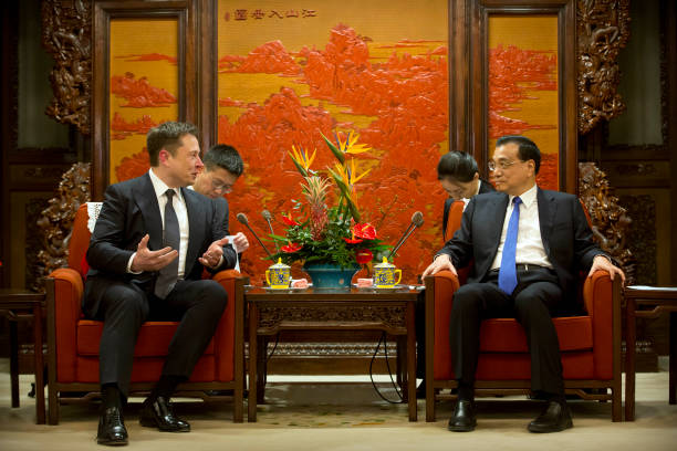 Tesla CEO Elon Musk speaks as Chinese Premier Li Keqiang listens during a meeting at the Zhongnanhai leadership compound in Beijing on January 9,...
