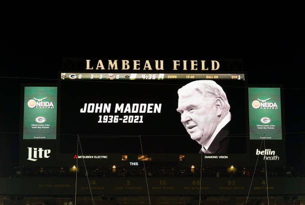 The scoreboard displays a tribute to John Madden after his recent death prior to the game between the Minnesota Vikings and the Green Bay Packers at...