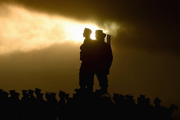 The sun breaks through the clouds behind a statue as both serving and former commandos gather during the Commando Memorial Service commemorate and...