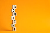 The word content on wooden cubes with yellow background. Content creation or management in business information technologies.
