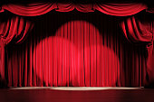 Theater stage with red velvet curtains and spotlights.