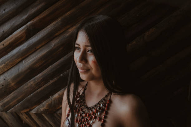 Thoughtful young Guarani woman looking away against bamboo wall, Misahualli,