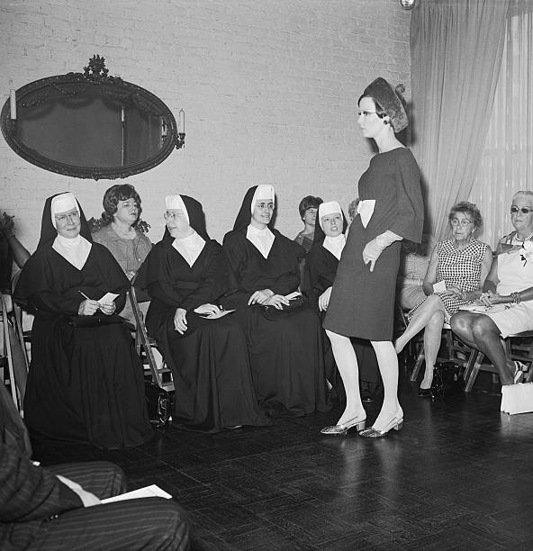 Three nuns, all members of the faculty at Mt. Mary College in Milwaukee, Wisconsin, look over one of the models at the viewing, June 8, of the fall...