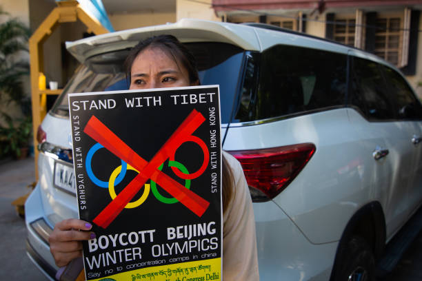 Tibetan student holds a placard calling for the boycott of the 2022 Beijing Winter Olympics during a protest on December 10, 2021 in Bengaluru,...