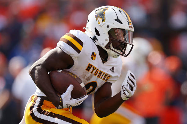 Titus Swen of the Wyoming Cowboys runs with the ball against the Illinois Fighting Illini during the first half at Memorial Stadium on August 27,...