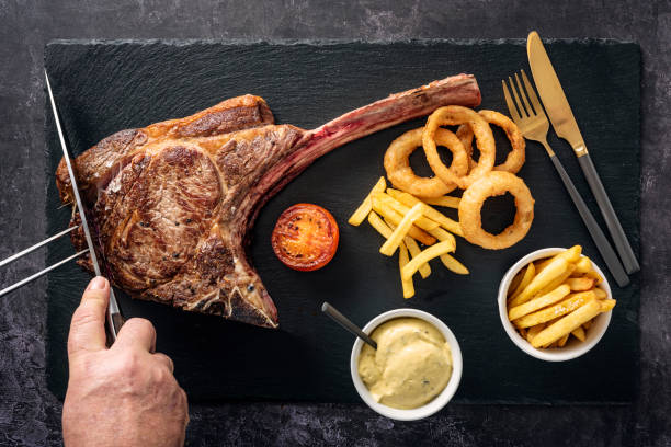 tomahawk steak with fries onion rings and bearnaise sauce being picture id1313473070?k=20&m=1313473070&s=612x612&w=0&h=NPs6I8DqojYI03FJQSaxn2