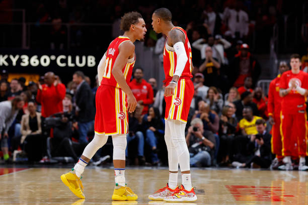 Trae Young and Dejounte Murray of the Atlanta Hawks react during the second half against the Houston Rockets at State Farm Arena on October 19, 2022...