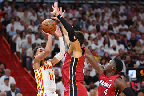 Trae Young of the Atlanta Hawks shot is defended by Max Strus and Victor Oladipo of the Miami Heat in Game Five of the Eastern Conference First Round...