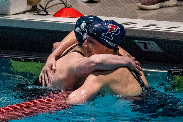 Transgender swimmer Lia Thomas of Penn University embraces transgender swimmer Iszac Henig of Yale after defeating him in the 100-yard freestyle...