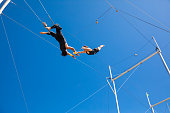 Trapeze artists flying in the blue sky