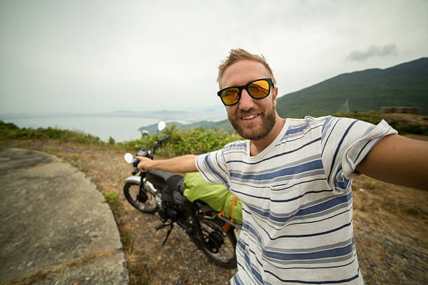 traveler on motorbike road trip taking a selfie - bike road trips vietnam stock pictures, royalty-free photos & images