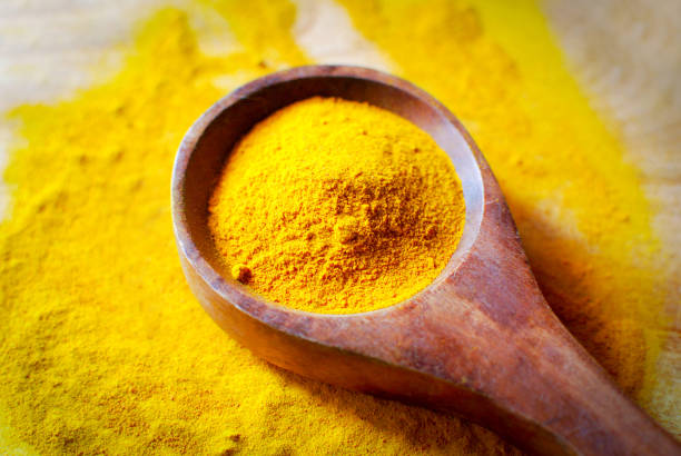 turmeric powder - wooden spoon - turmeric stock pictures, royalty-free photos & images