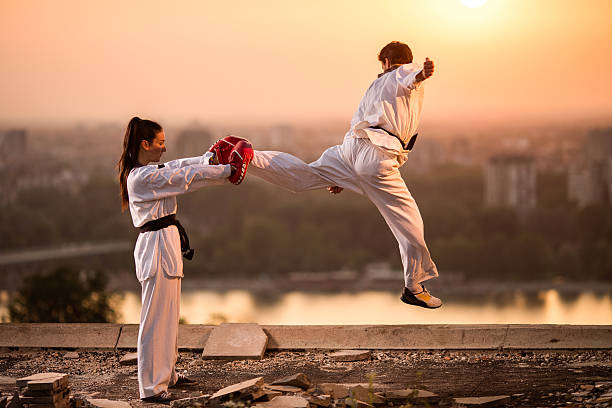 Two black belt sparring partners exercising at sunset.