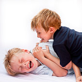 two brothers fighting and playing roughly on white background