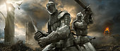 Two Medieval Knights With Swords On Battlefield Near Ruined Monuments