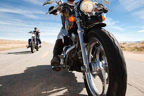 two men riding motorcycles along road - バイク ストックフォトと画像