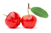 Two red acerola cherry fruit  with green leaf isolated on white background.