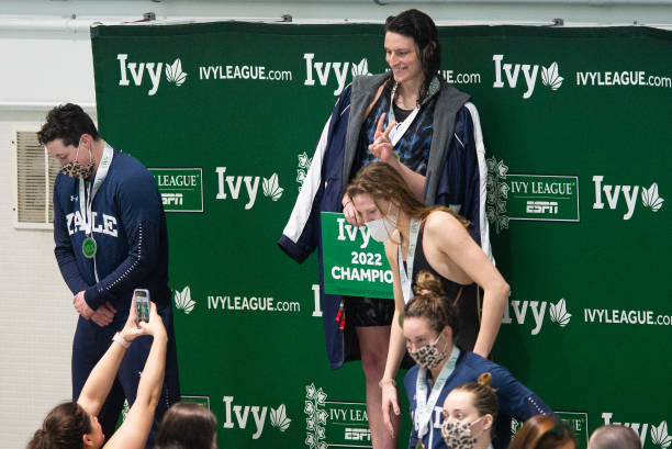 University of Pennsylvania swimmer Lia Thomas poses on the podium after winning the 100 yard freestyle, Yale University swimmer Iszac Henig finished...