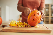 Unrecognizable Woman Carving Pumpkin