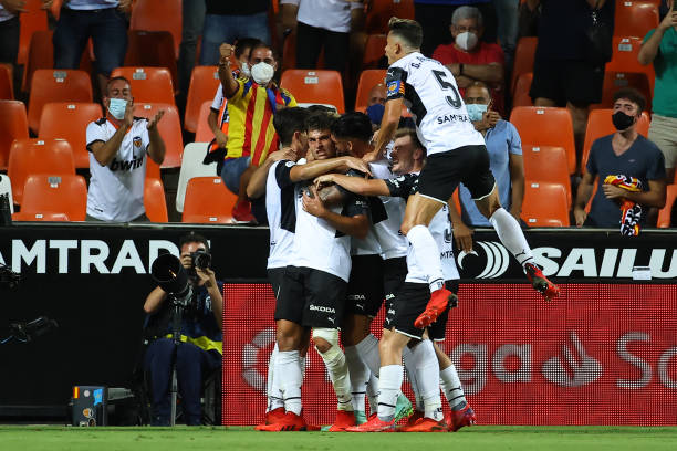 Valencia players celebrate the opening goal scored by Valencia's Spanish forward Hugo Duro during the Spanish League football match between Valencia...
