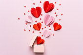 Valentine day composition with gift box and red hearts, photo template on pink background.