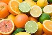 Variety of full and halved citrus fruit