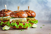 Vegan falafel burger with vegetables and sauce, dark background, copy space. Healthy  plant based food concept.