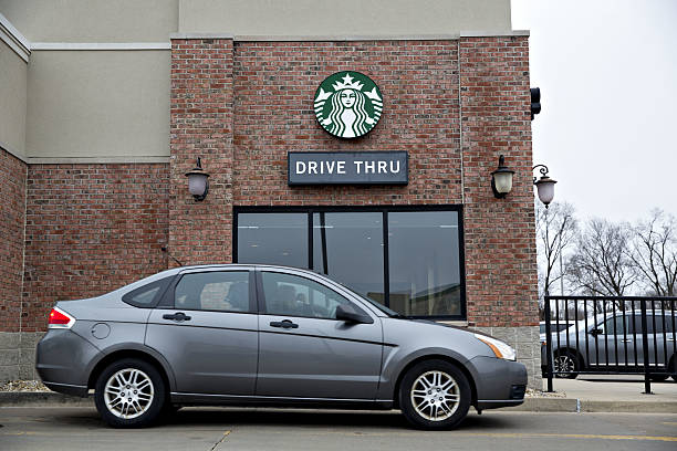 vehicle stands at the drive thru of a starbucks corp coffee shop in picture