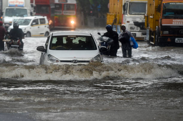 Vehicles drive through flooded street during rain showers in Mumbai on July 5, 2022.