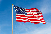 Vibrant colored American Flag waving in the wind, lit by natural sunlight