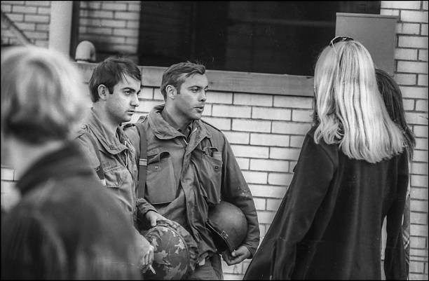 View of a pair of Ohio National Guardsmen as they talk with female Kent State University students on the university's campus in the wake of student...