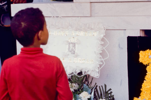 View of an unidentified young boy as he stands in front of Dr Martin Luther King Jr's headstone, Atlanta, Georgia, April 9, 1968.