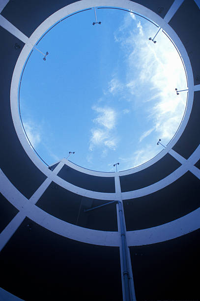 View up through circular stairway and blue sky at a sports stadium