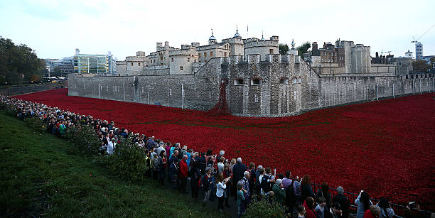 Visitors view the 'Blood Swept Lands and Seas of Red' installation at Tower of London on October 30 2014 in London England The installation by...