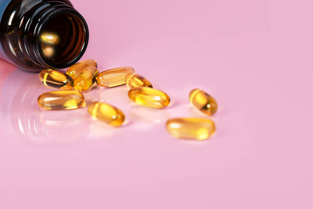vitamin d bottle with capsules on yellow background. omega 3. - cod liver oil stock pictures, royalty-free photos & images