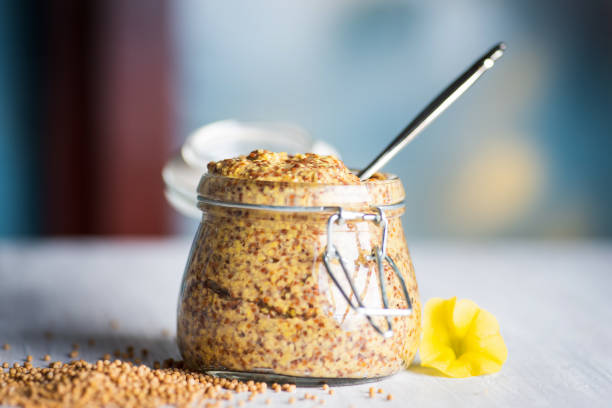 wholegrain mustard in a jar on a table - mustard stock pictures, royalty-free photos & images