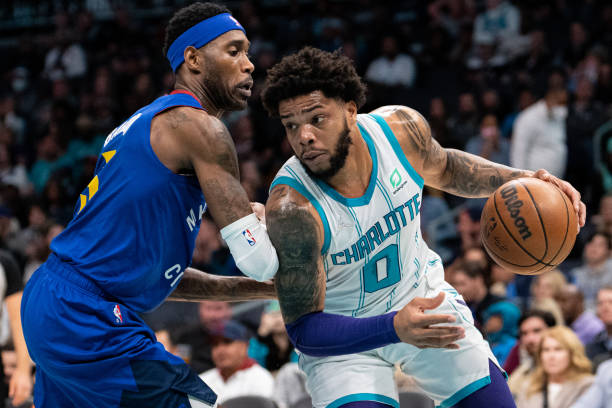 Will Barton of the Denver Nuggets guards Miles Bridges of the Charlotte Hornets in the first quarter at Spectrum Center on March 28, 2022 in...