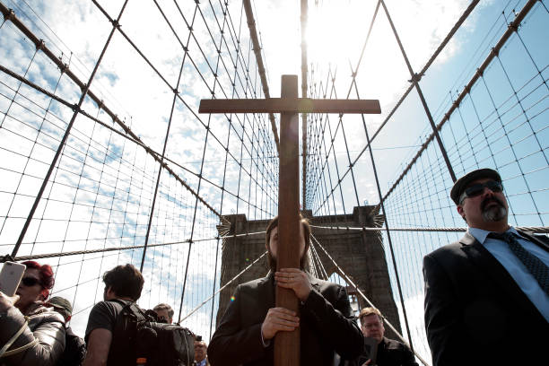 With Vitality Kuzmin carrying the cross, the Way of the Cross procession makes its way across the Brooklyn Bridge on Good Friday, April 14, 2017 in...