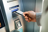 Withdrawing Money from ATM Machine by businessman