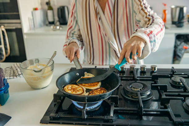 woman cooking homemade pancakes for breakfast - gas de casa - fotografias e filmes do acervo