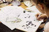 Woman designer makes and design jewelry in workshop