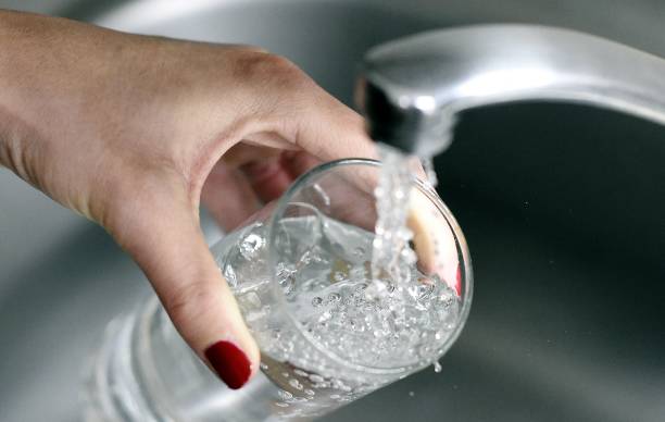 Woman fills up a glass with water on April 27, 2014 in Paris. Eight out of ten people in France say they have ''confidence'' in tap water, according...