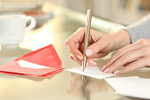 Woman hand writing greeting card at home