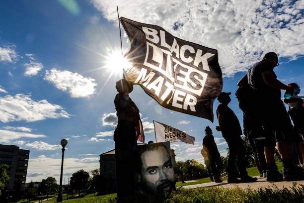 Woman holds a Black Lives Matter flag during an event in remembrance of George Floyd and to call for justice for those who lost loved ones to the...