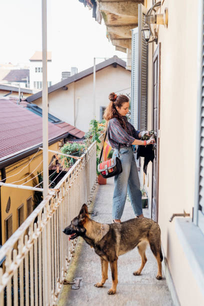 woman locking door while standing with dog at balcony picture